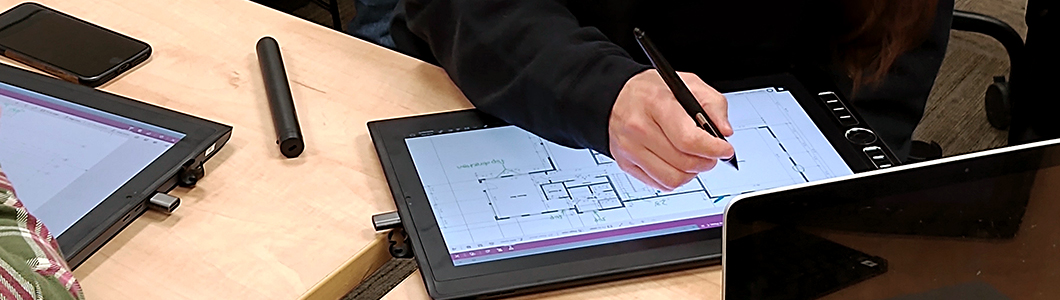 A person makes adjustments to a blueprint on a tablet screen.