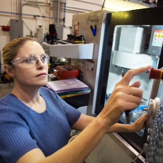 Student Bobbie Ketelhut uses a CNC machine to complete course labwork.