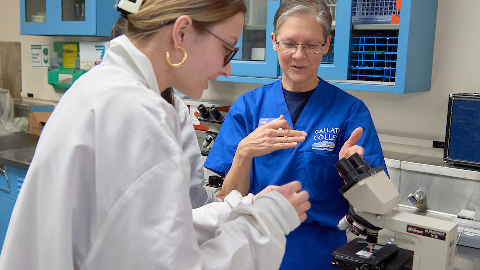 An Allied Health instructor demonstrates how to properly insert a slide into microscope.