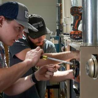 HVAC students complete work on a furnace.