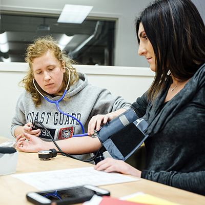 Students taking blood pressures in a healthcare course